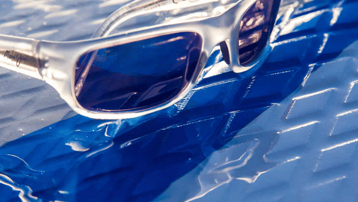 A pair of sunglasses sitting on top of a blue surface.