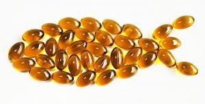 A fish made out of fish oil capsules on a white background.