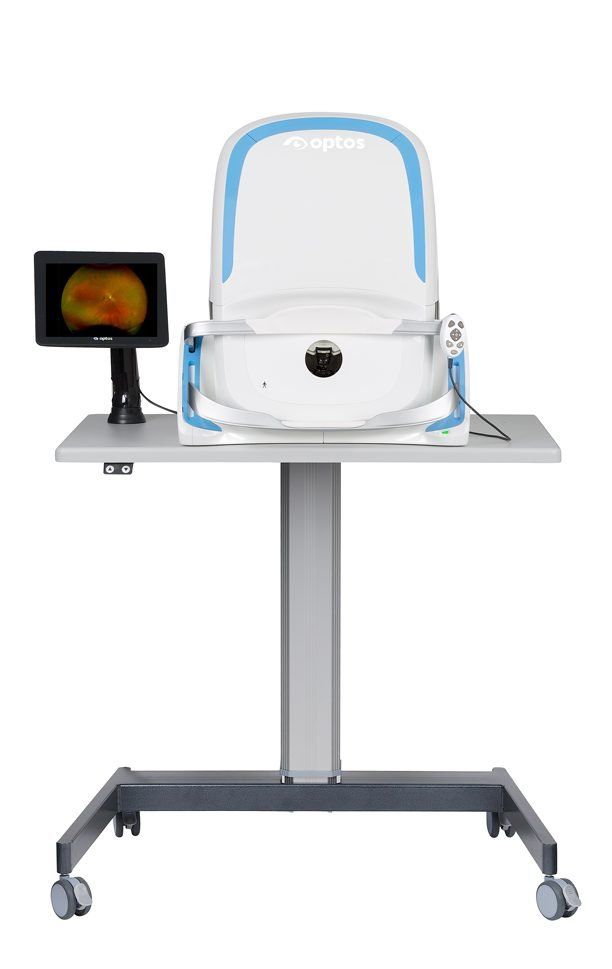 A chair is sitting on top of a table next to a monitor.