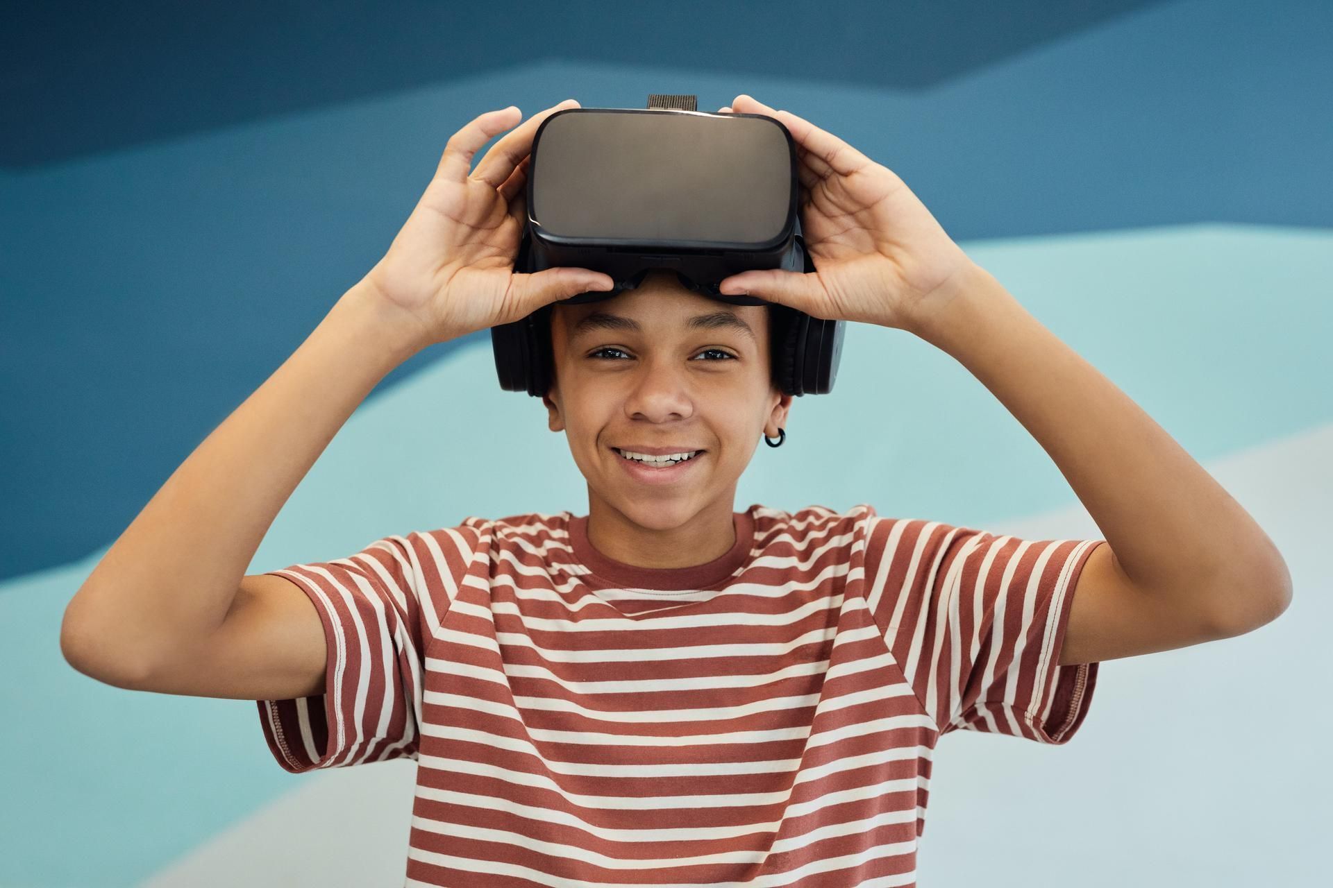 A young boy is wearing a virtual reality headset.