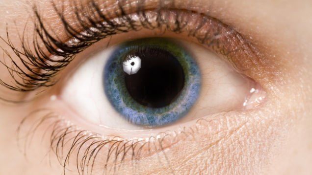 A close up of a woman 's blue eye with long eyelashes.