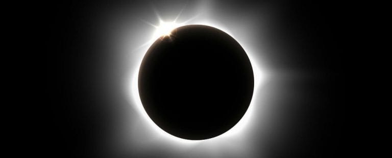 The moon is covering the sun during an eclipse.
