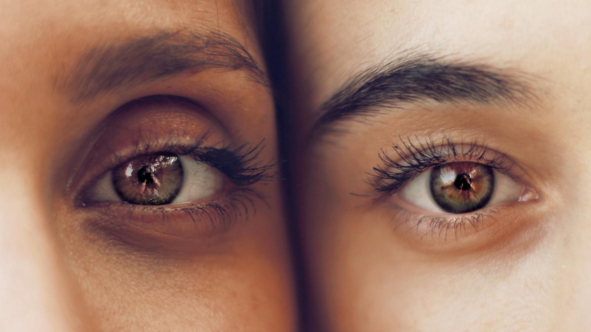 A close up of two women 's eyes and eyebrows.
