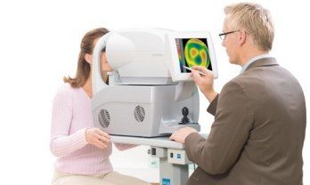 A woman is getting her eyes examined by an ophthalmologist
