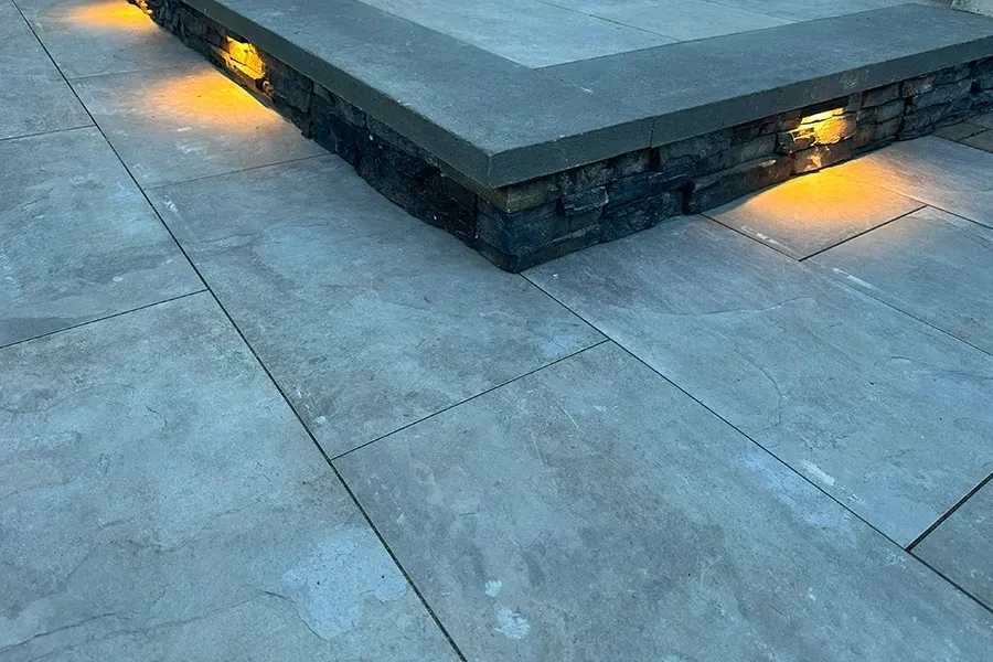 Modern stone patio with recessed yellow lights under an elevated platform