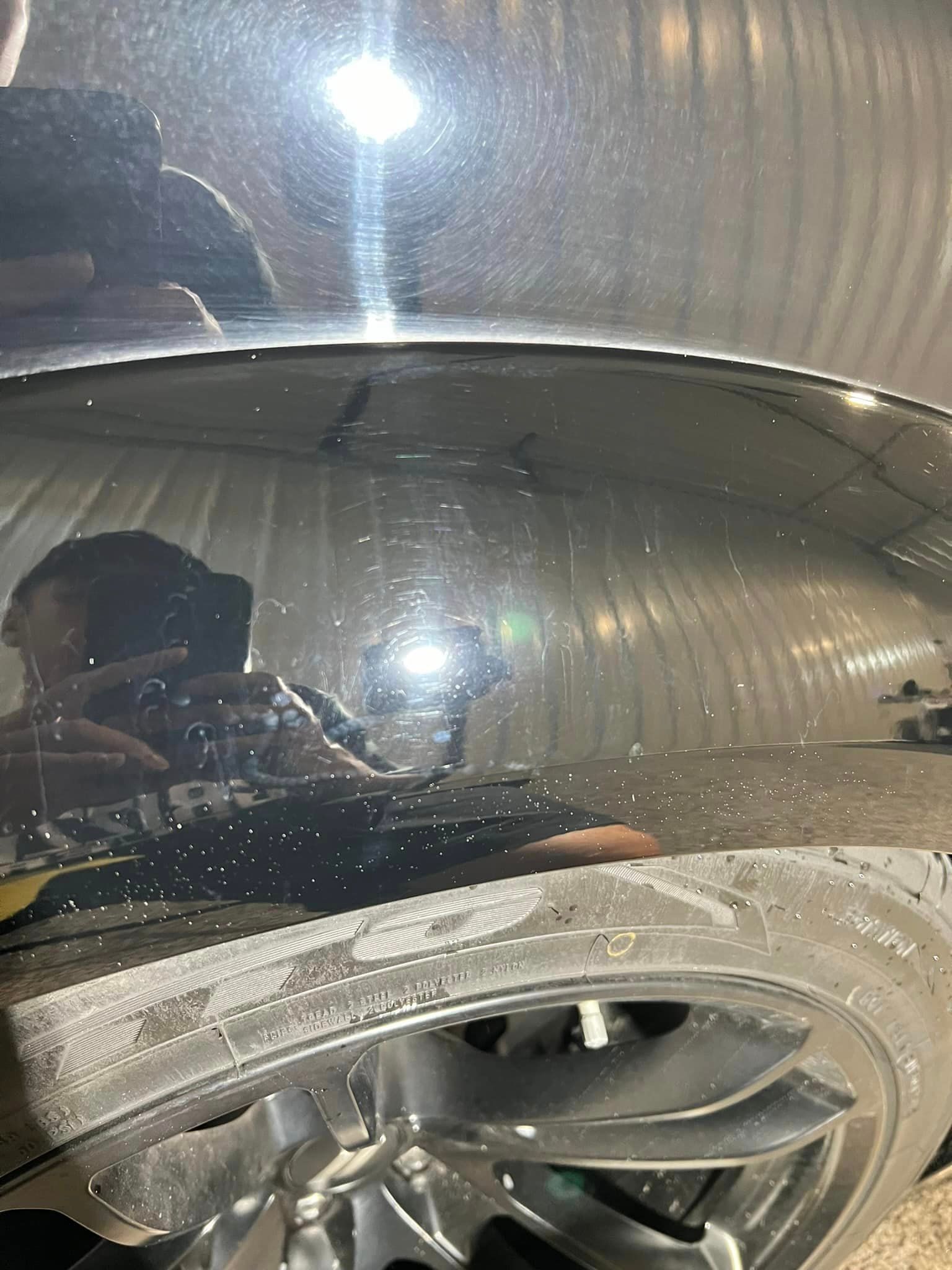 A person is taking a picture of their reflection in the windshield of a car.