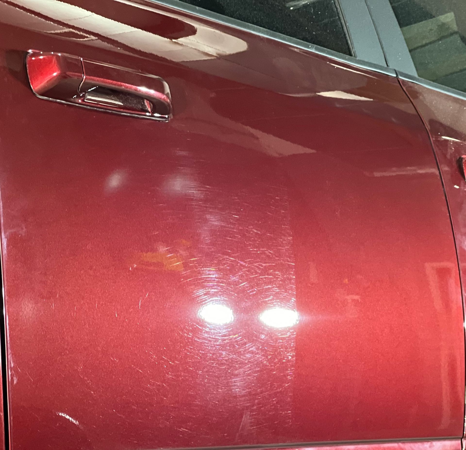 A close up of a red car door with a handle