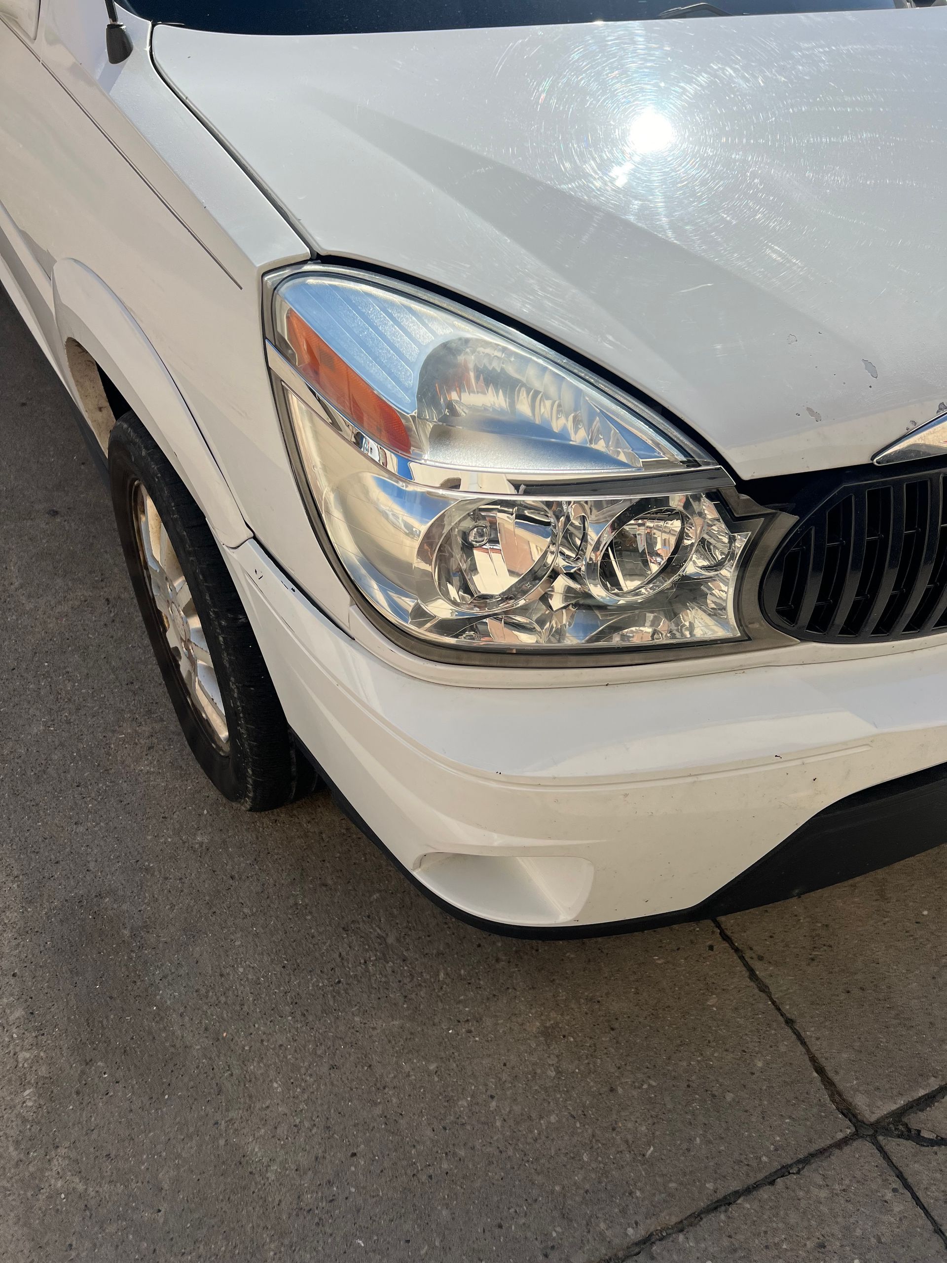 A white car is parked on the side of the road