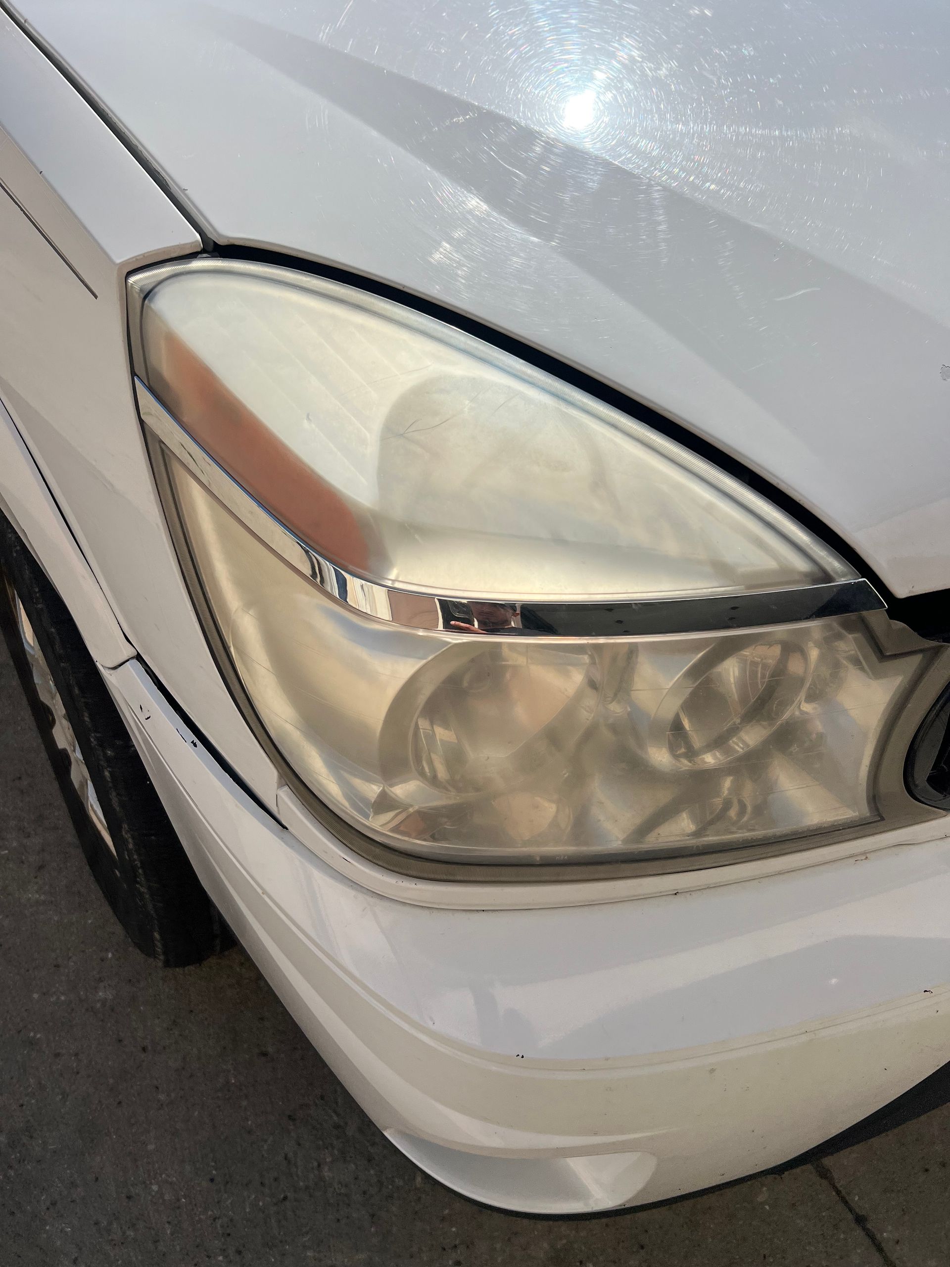 A close up of a white car 's headlight