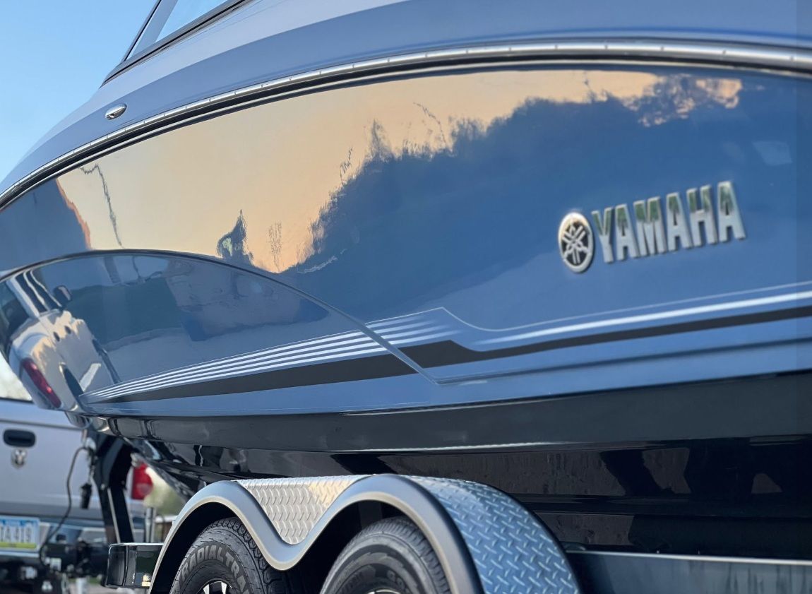 Blue and white Yamaha boat with a black cover, shown indoors at an angle.