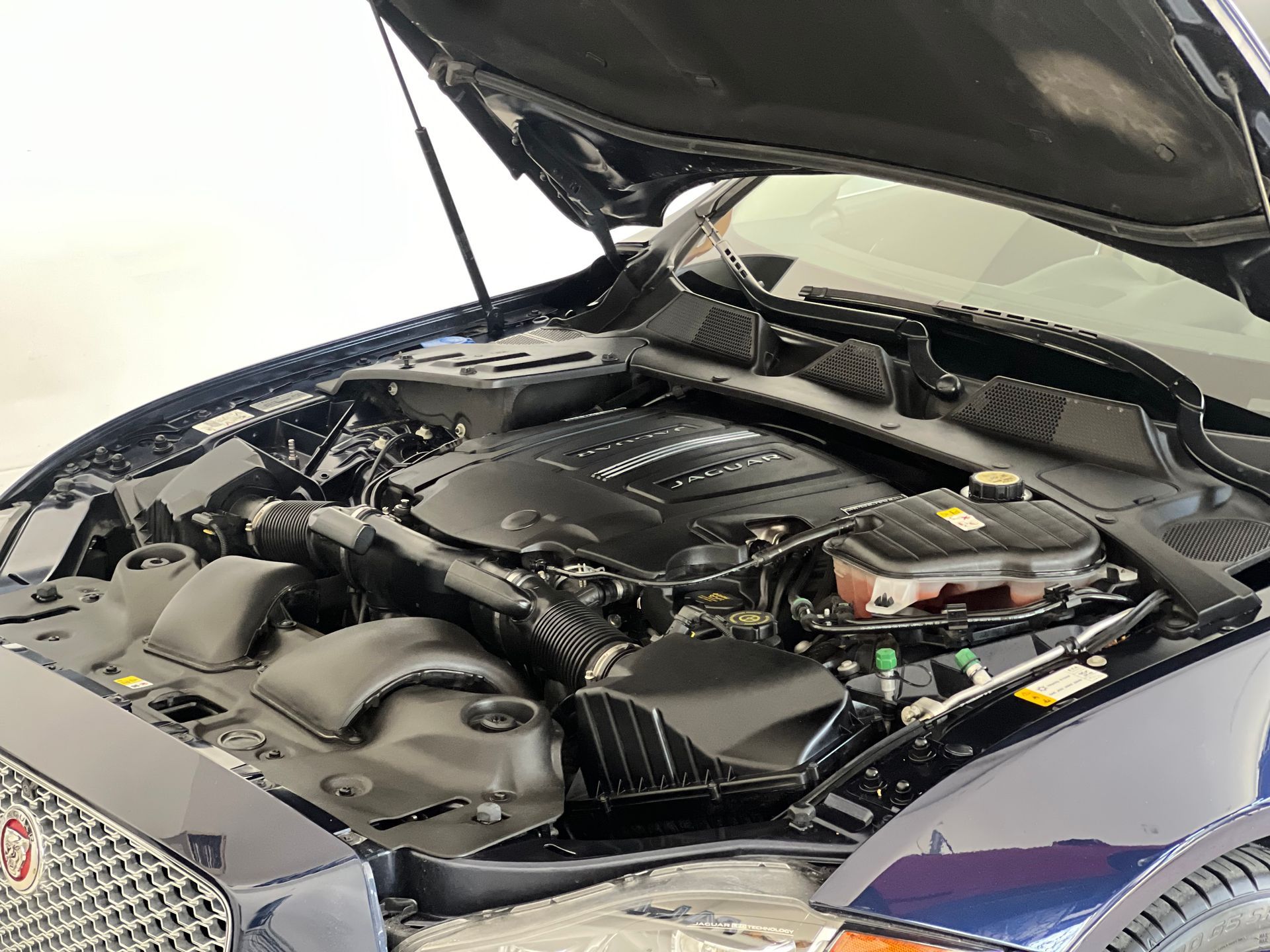 A close up of the engine of a car with the hood open.