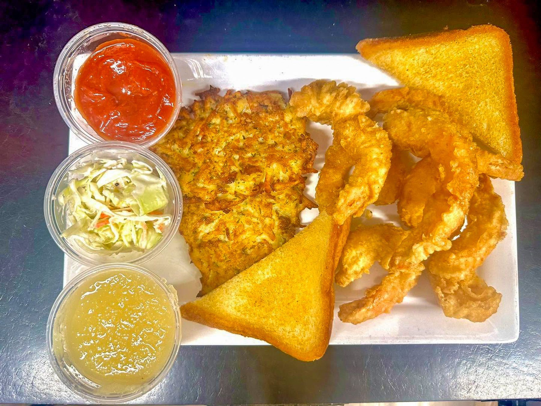 Plate with fried food, toast, shrimp, coleslaw, and sauces on a tray