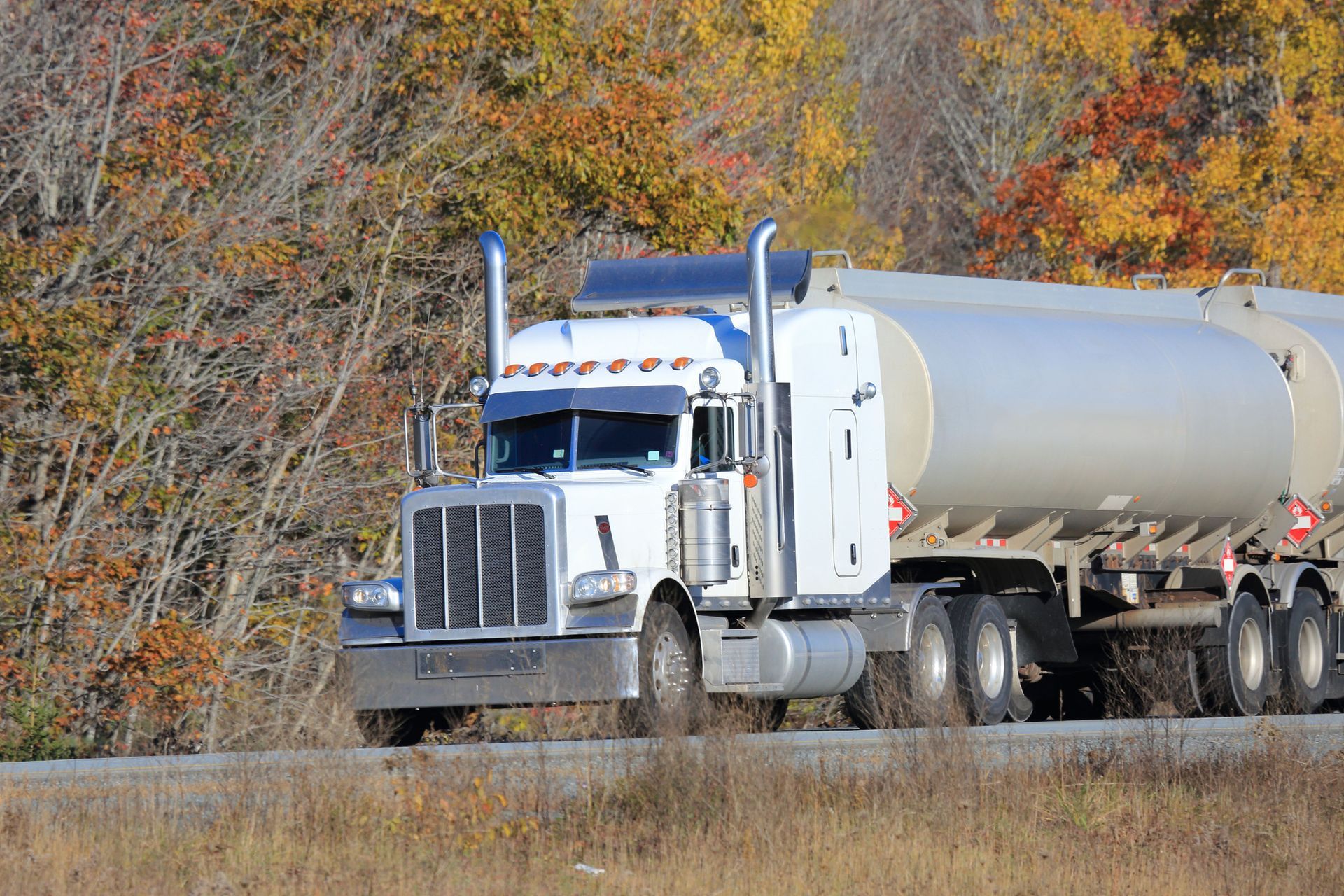 Two fuel trucks are parked next to each other in a parking lot.