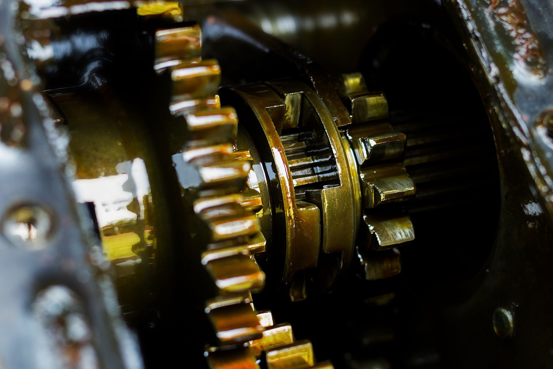 A close up of a gearbox with a lot of oil on it.