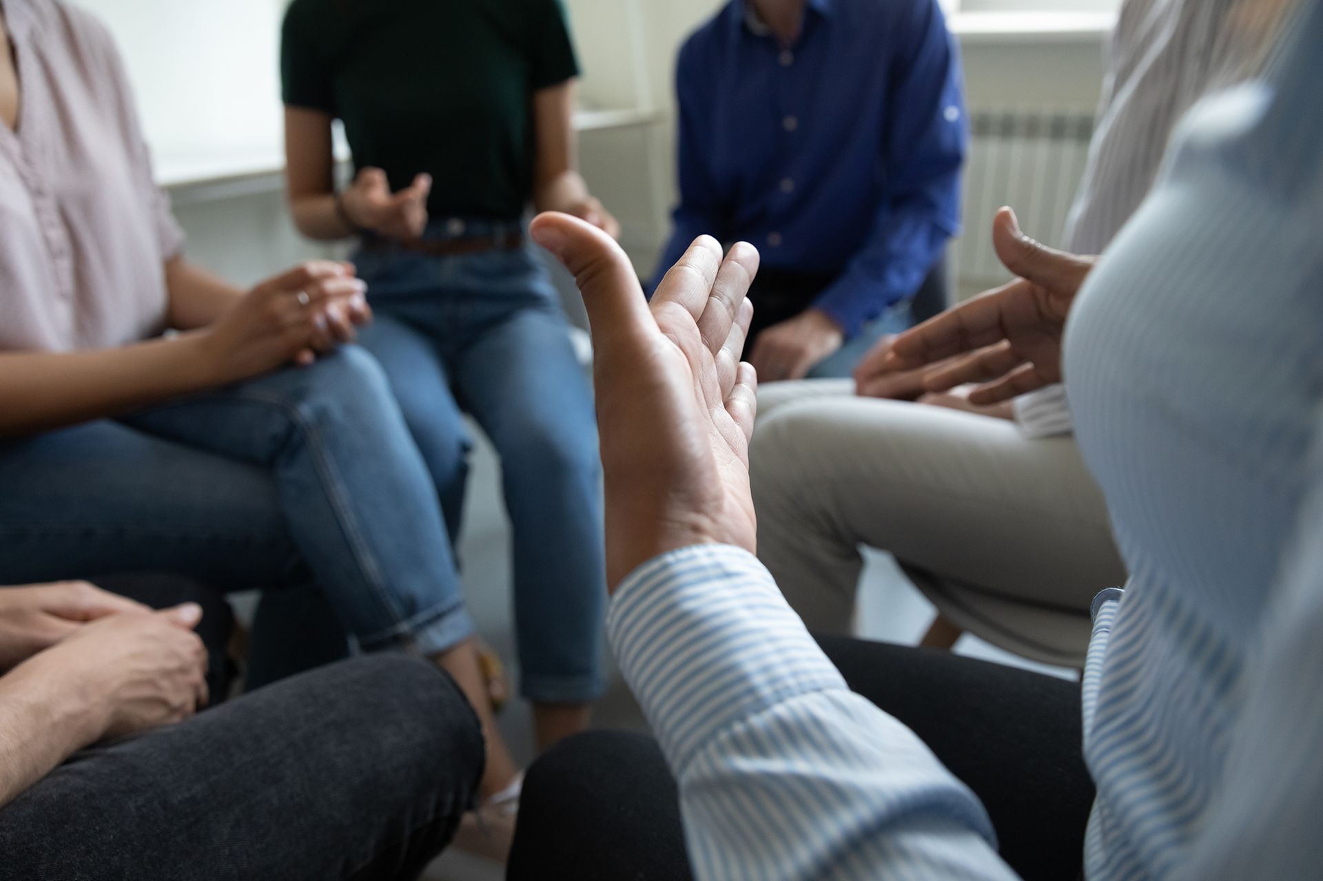 A group of people are sitting in a circle talking to each other.