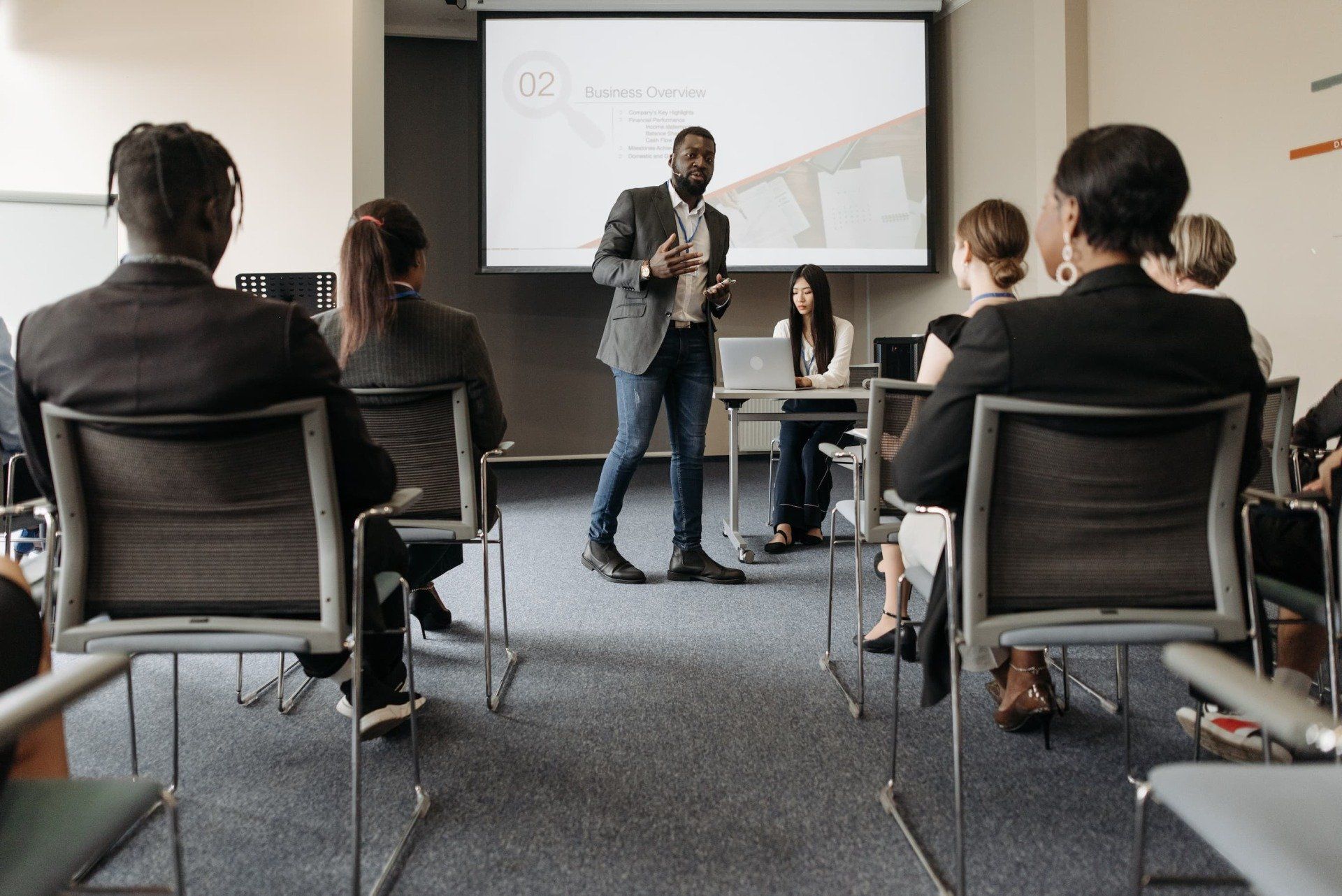 A man is giving a presentation to a group of people in a conference room.
