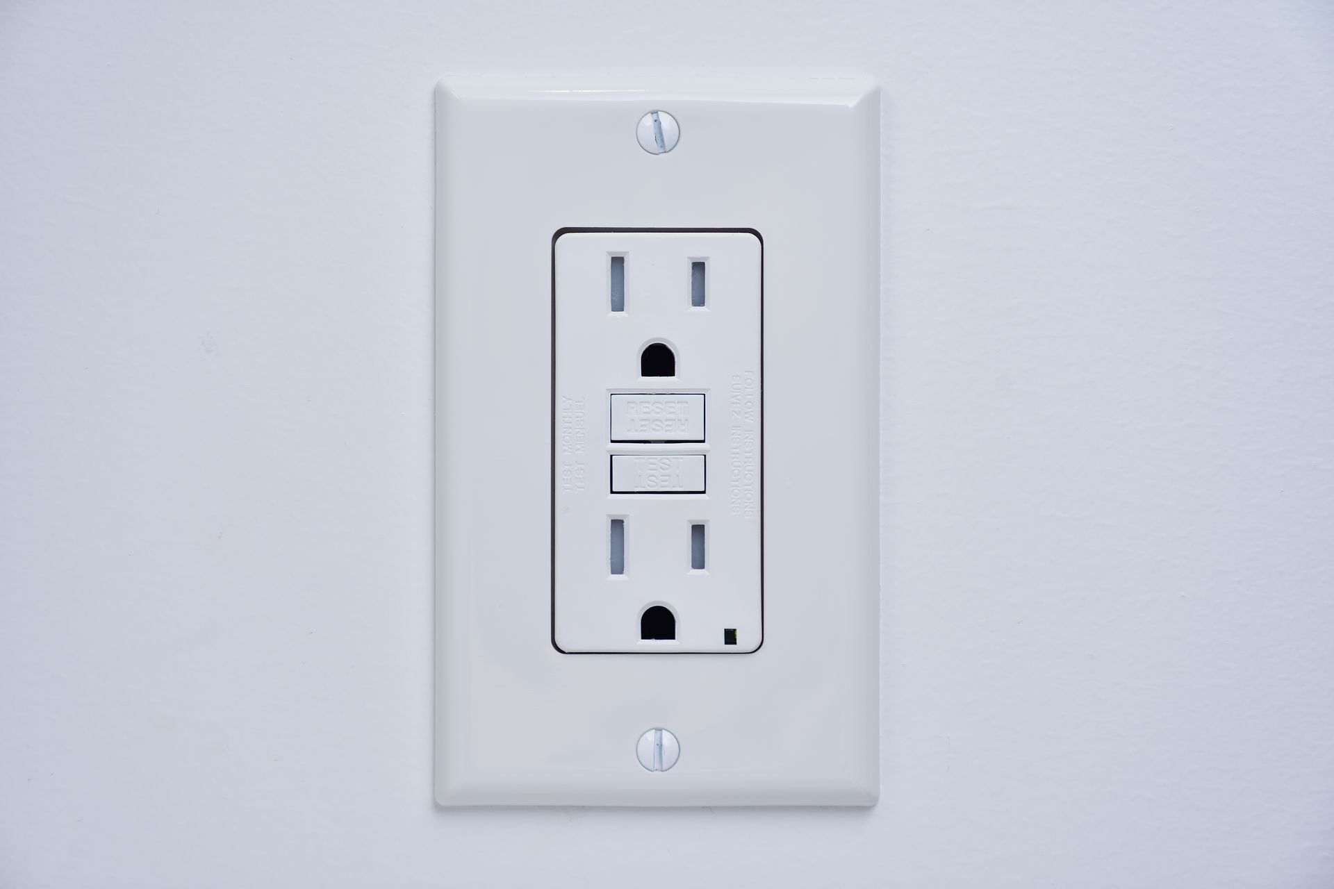 White GFCI electrical outlet on a light gray wall