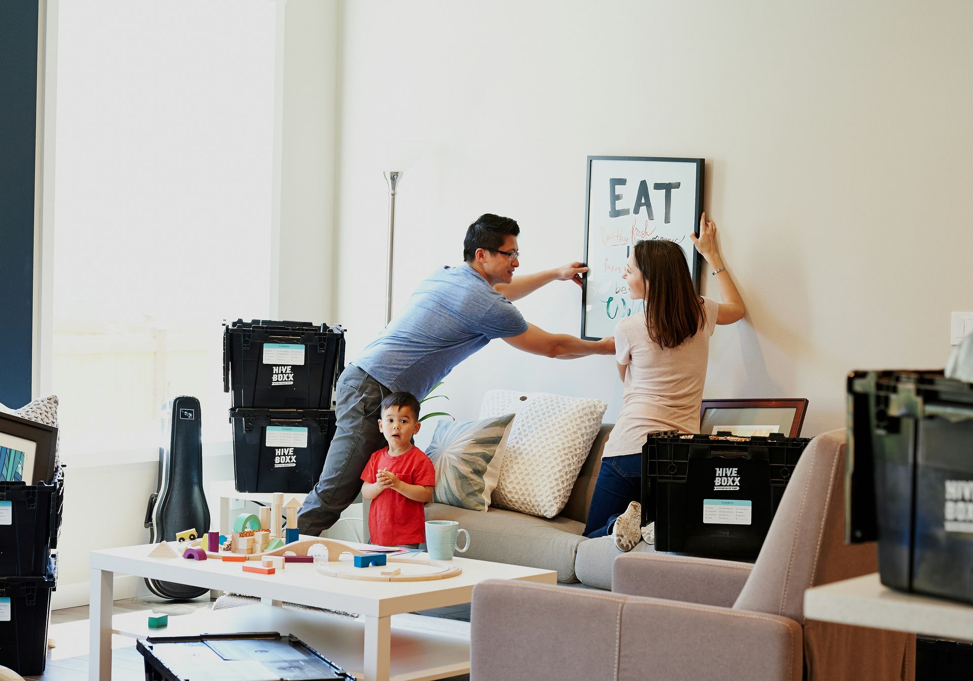 two first-time renters hanging poster in Portland apartment