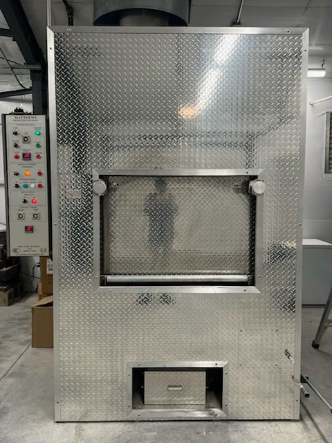 Stainless steel industrial incinerator with control panel.
