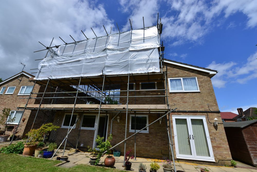 Scaffolding and White Tarp Covering a House