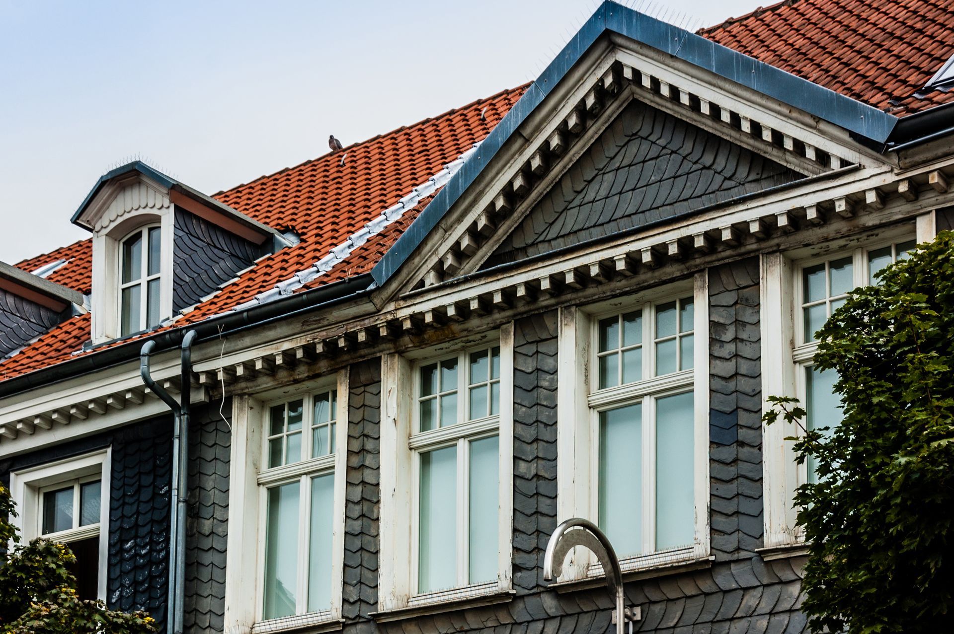 Modern house exterior featuring dark cladding and brick walls under a pitched roof.