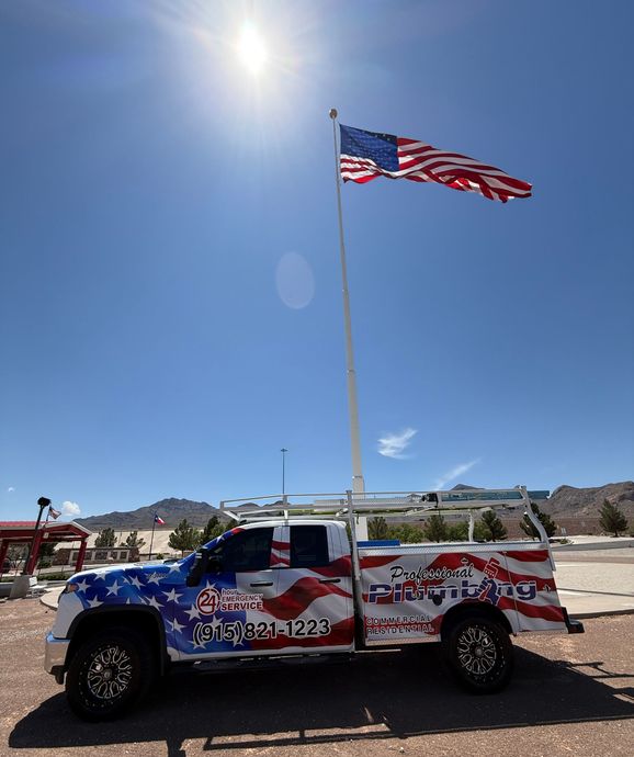 Patriotic flag-themed off-road vehicle under a tall American flag on a sunny day