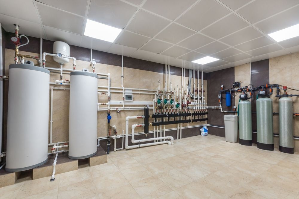 Industrial water treatment room with tanks, pipes, valves, and filtration equipment on tiled floor