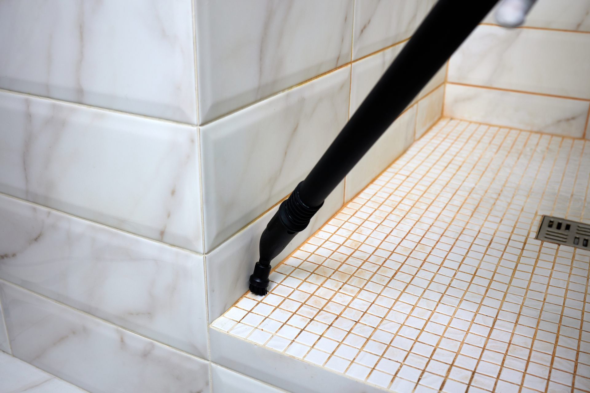 Black grab bar attached to a tiled shower wall and floor corner