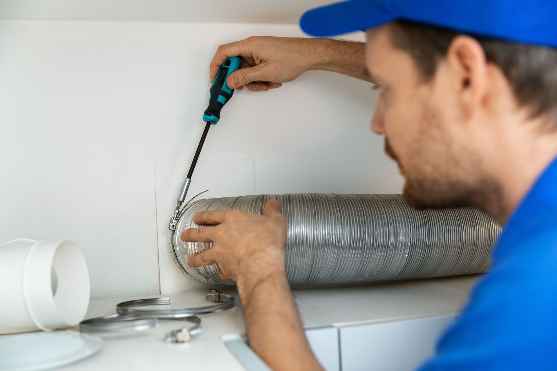 worker installing flexible aluminum ventilation tube