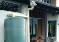 A large blue water tank is attached to the side of a house.