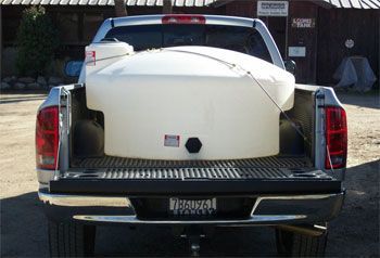 A white tank is in the back of a truck