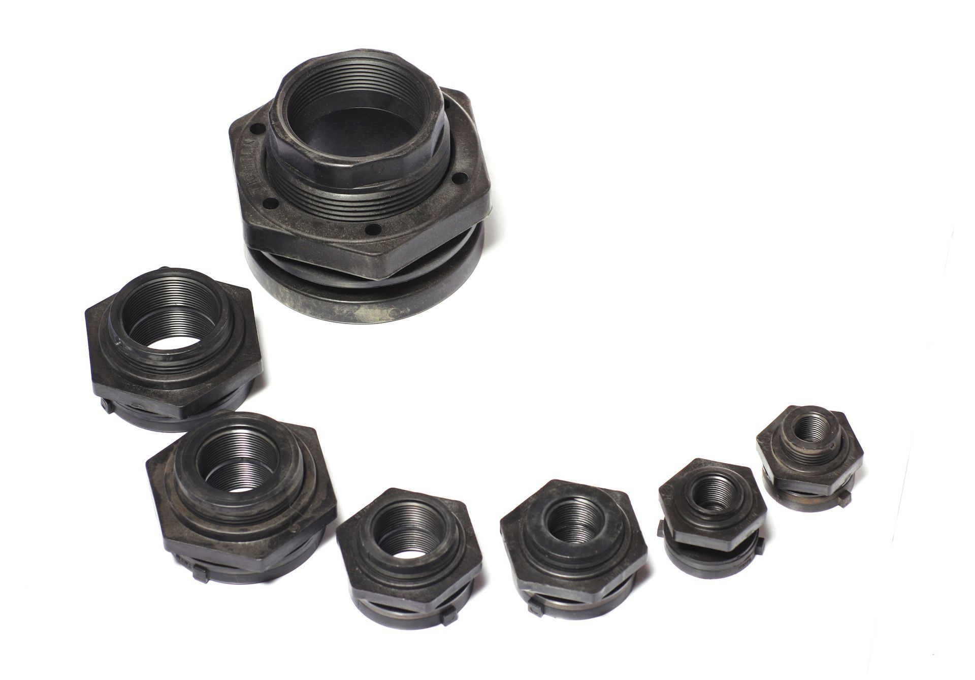 A bunch of black plastic nuts and washers on a white background