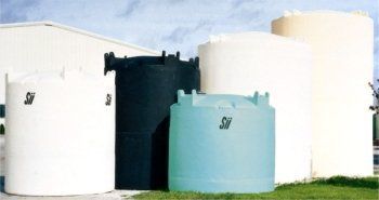 A group of water tanks are lined up in front of a building