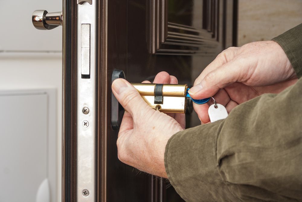 Hands Using a Key and Lock Cylinder on A Door Lock — My Handyman Townsville In Garbutt, QLD
