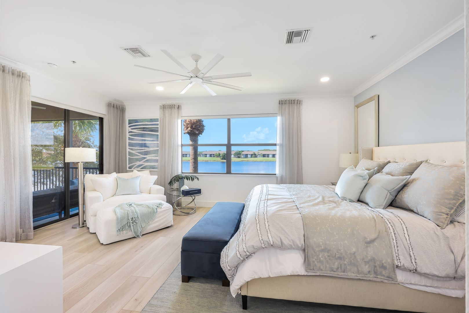 A bedroom with a large bed and a ceiling fan.