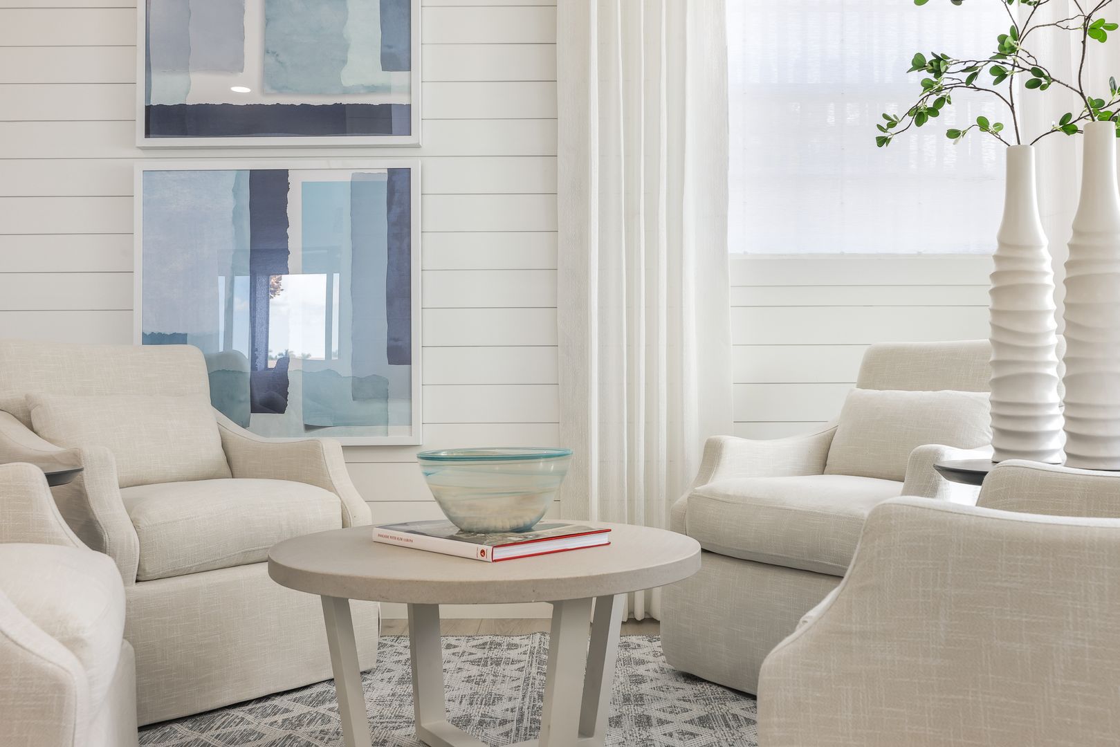 A living room with white furniture and a round table