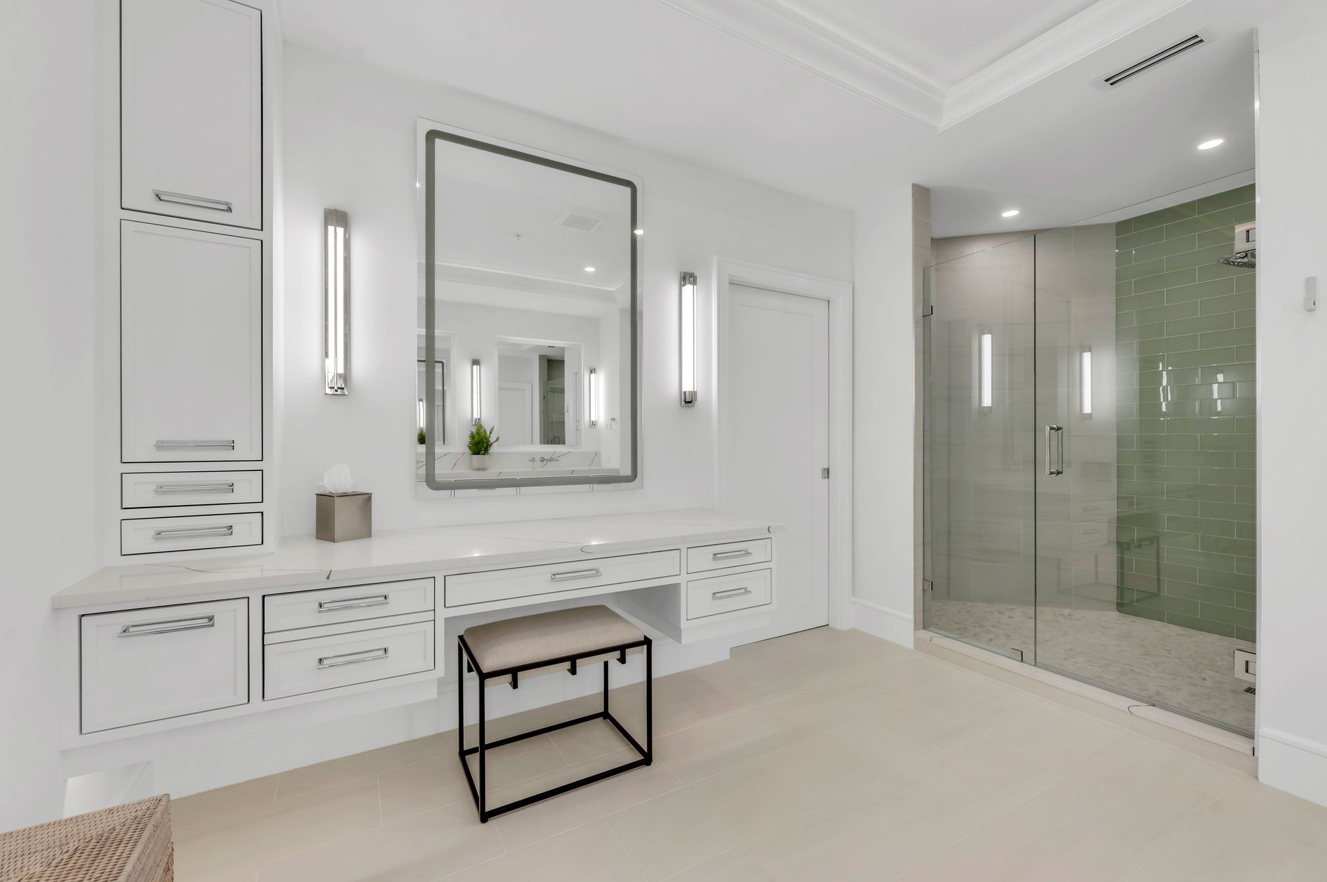 A bathroom with a vanity , mirror , stool and walk in shower.