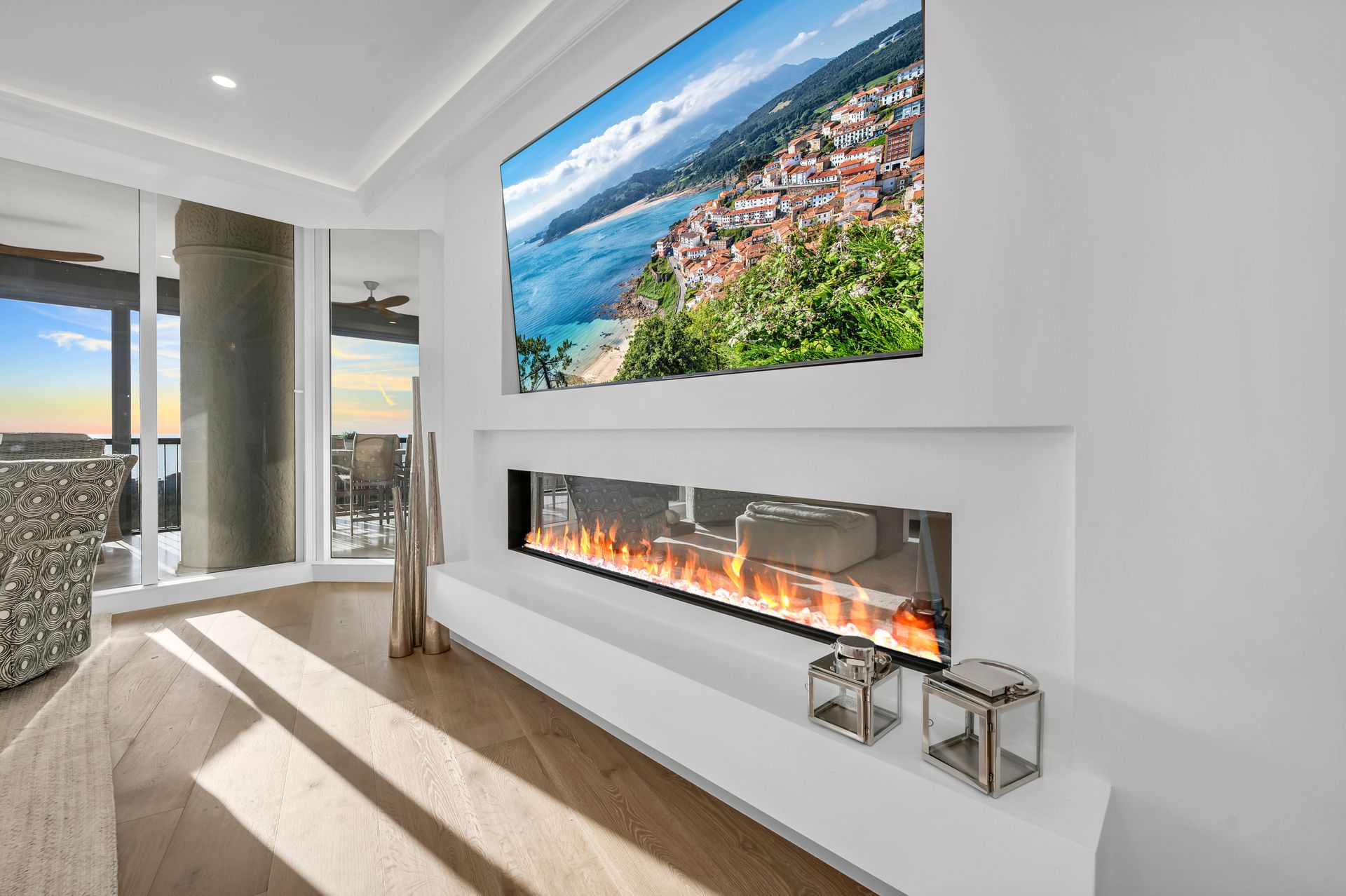 A living room with a fireplace and a large television on the wall.