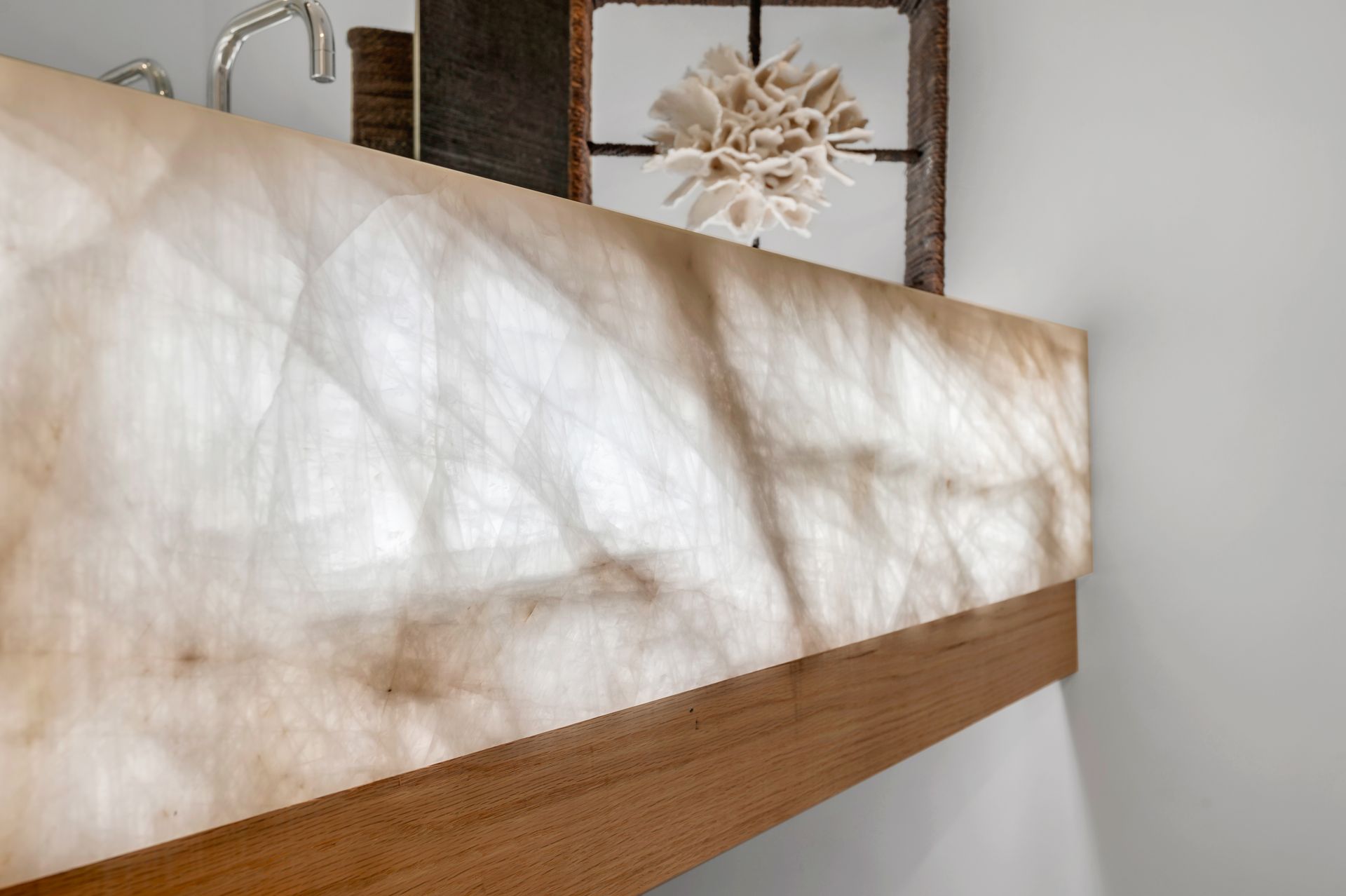 A bathroom sink with a marble counter top and a wooden frame.
