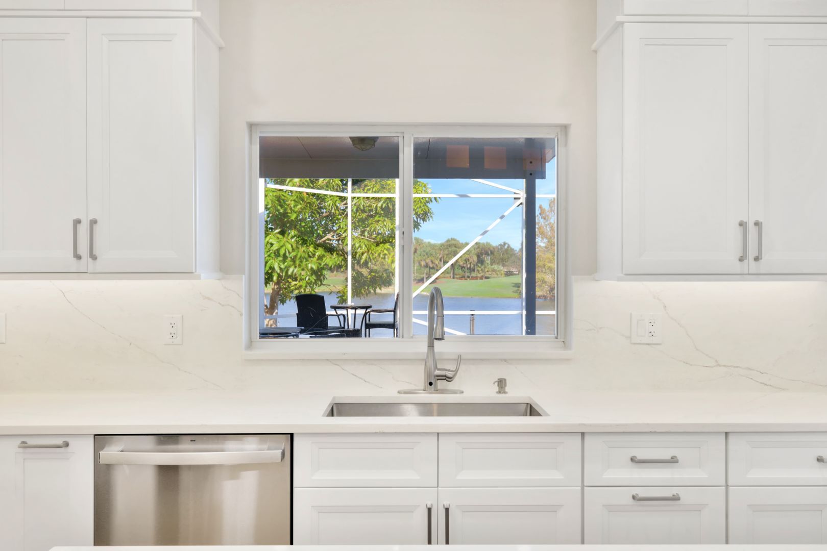 A kitchen with white cabinets and a stainless steel dishwasher