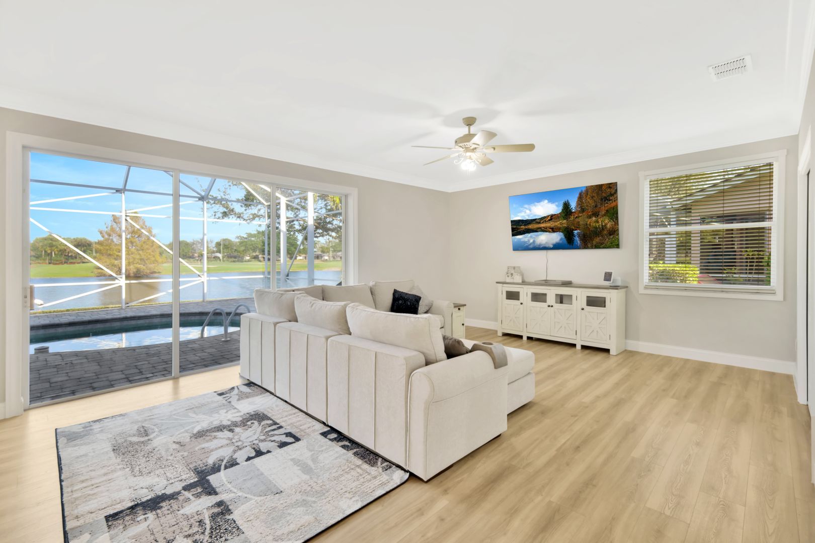 A living room with a couch , rug , and ceiling fan.