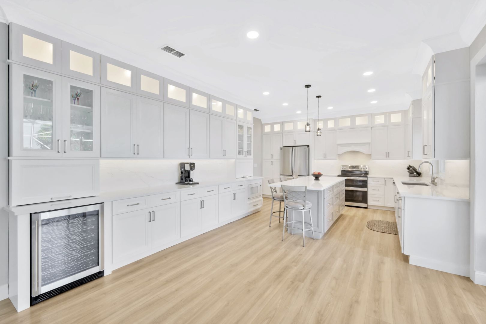 a large kitchen with white cabinets and wooden floors .