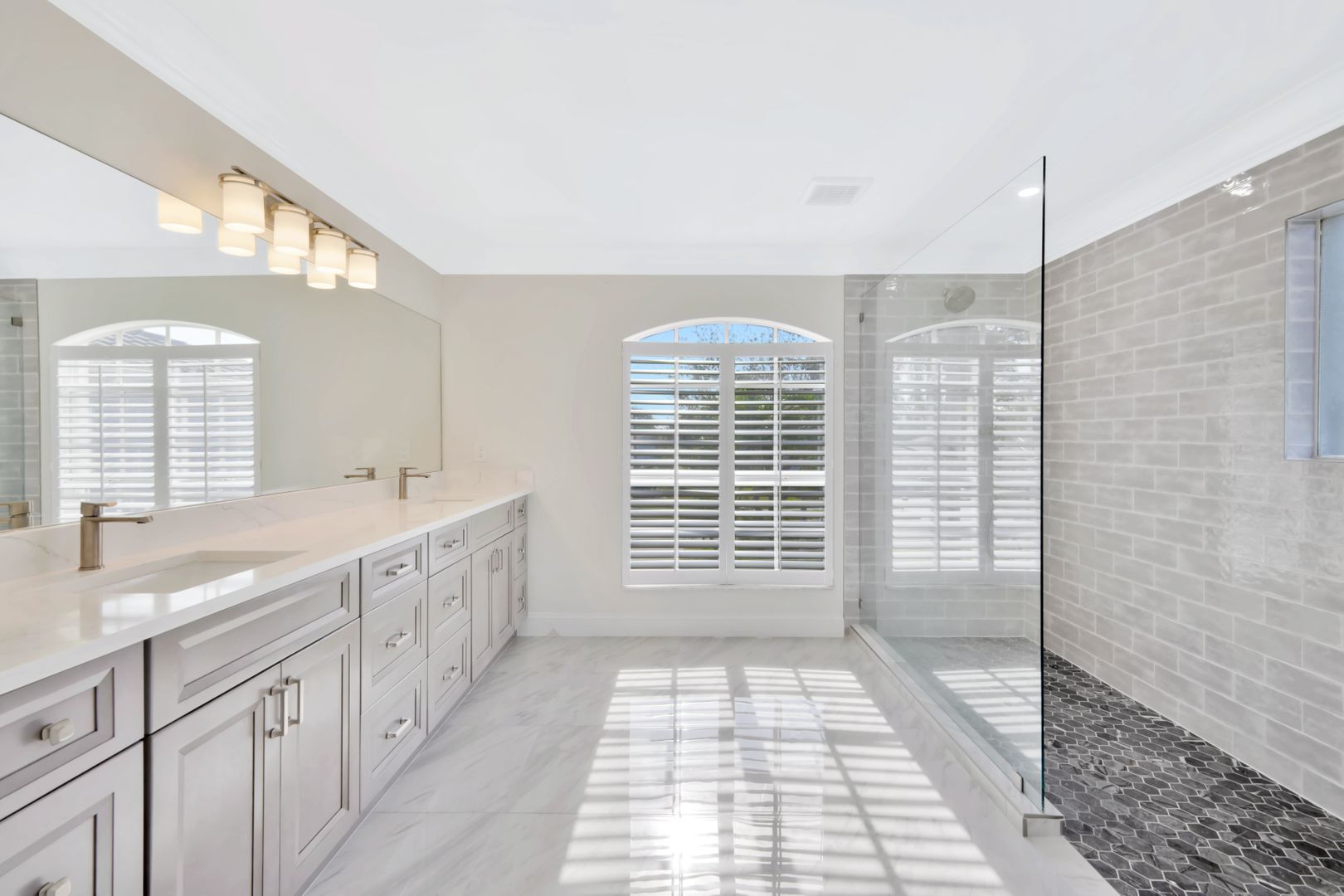 a bathroom with two sinks and a walk in shower .