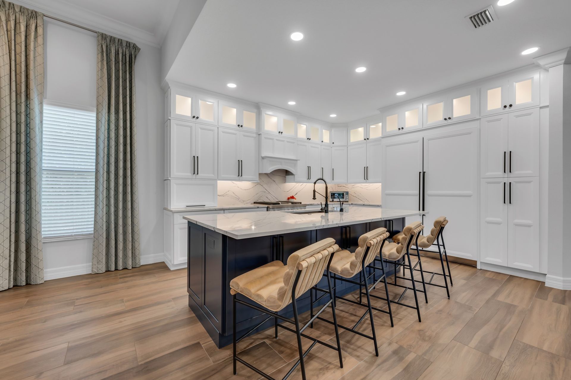 A large kitchen with a large island and stools.