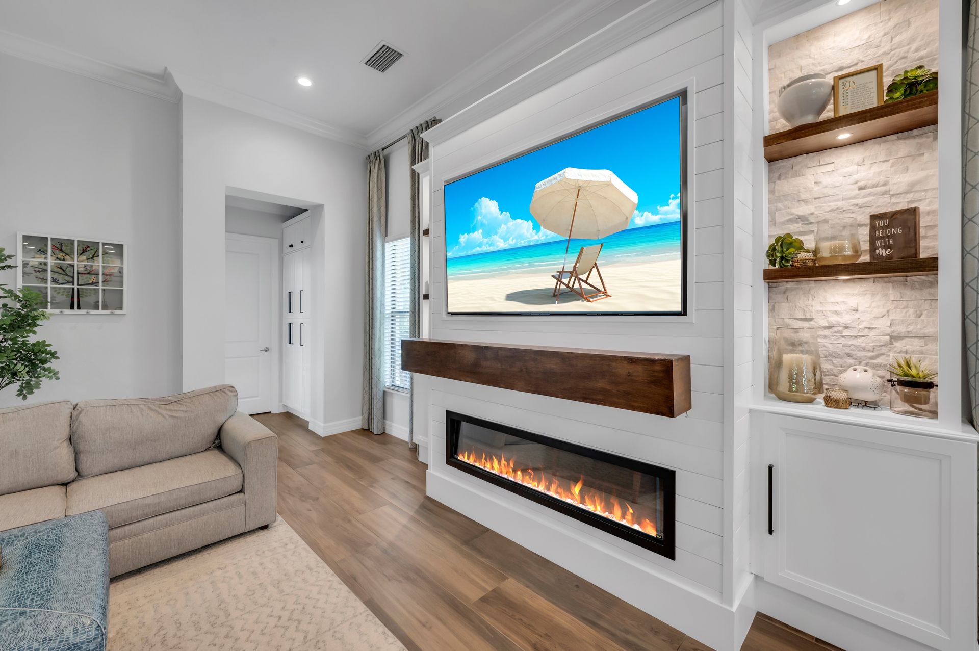 A living room with a fireplace and a flat screen tv on the wall.