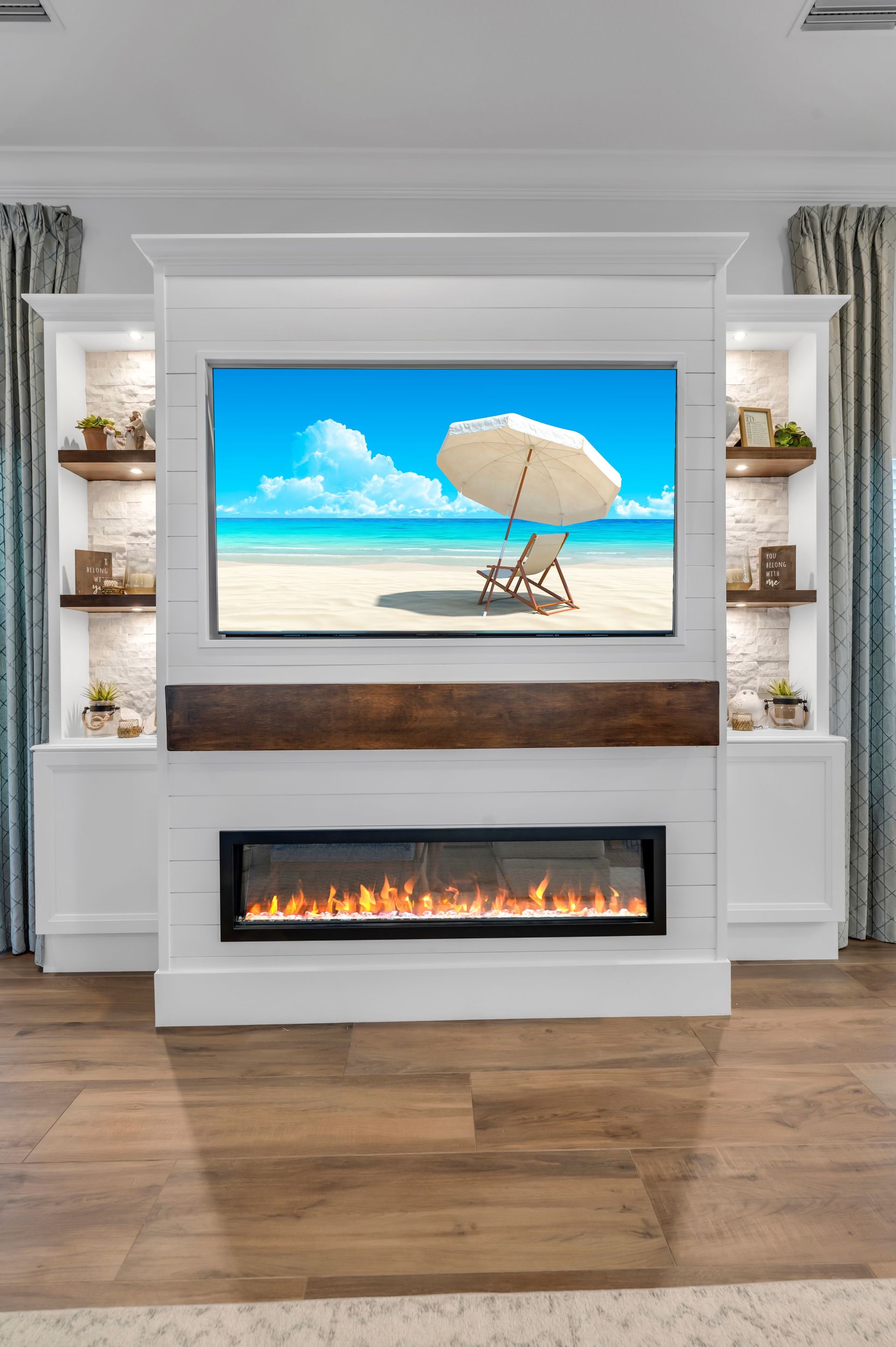 A living room with a fireplace and a flat screen tv on the wall.