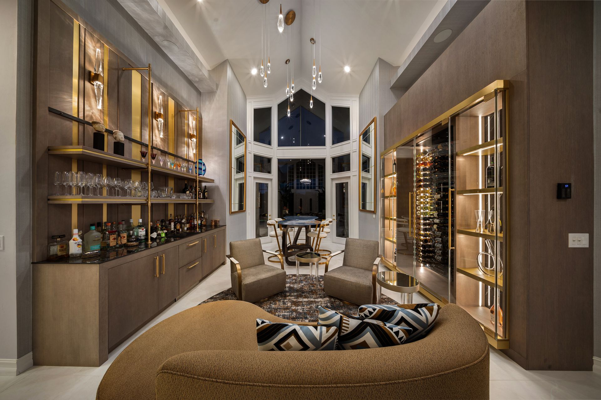 A living room with a couch , chairs , shelves and a bar.