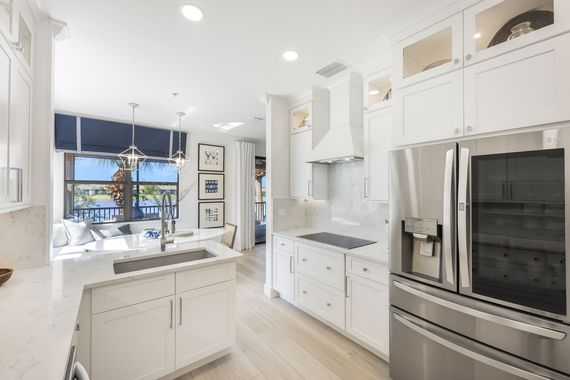 a kitchen with white cabinets and stainless steel appliances .