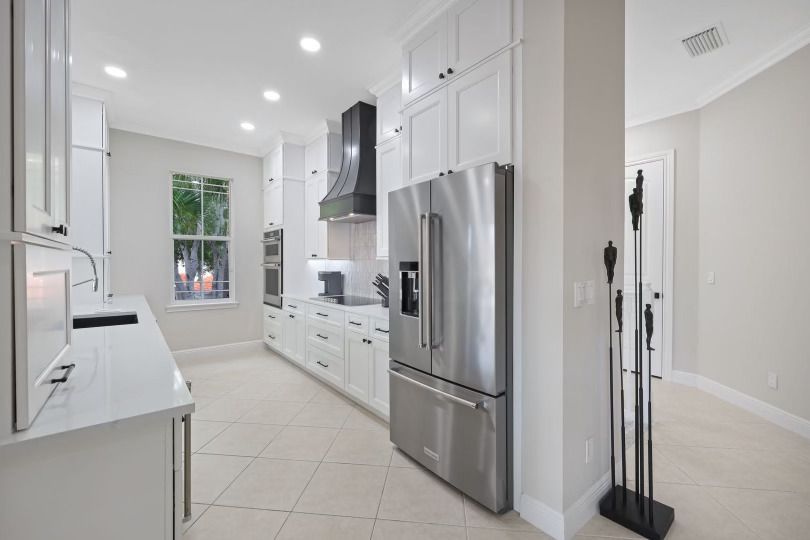 A kitchen with stainless steel appliances and white cabinets.