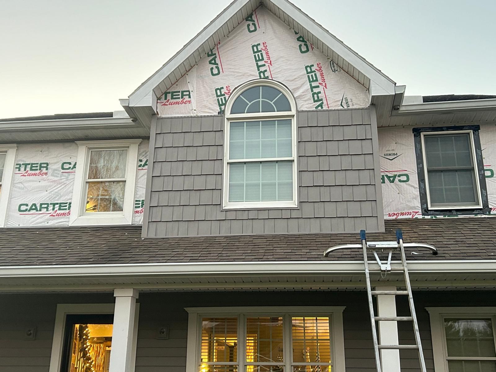A man is working on the roof of a house.